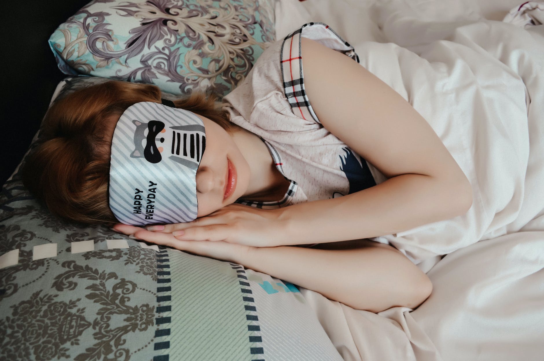 unrecognizable woman in sleep mask lying on bed